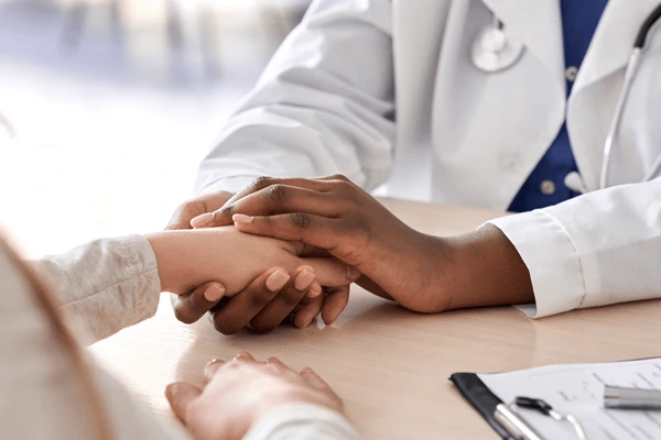 A doctor holding hands with another person.